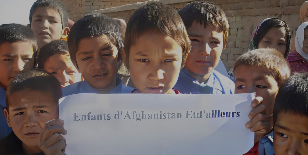 Des enfants présentent une affiche de l'association Enfants d'Afghanistan et d'ailleurs